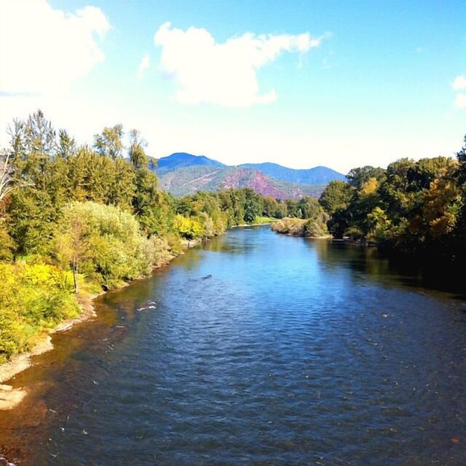 Breathe in open skies beside a calm, flowing river.