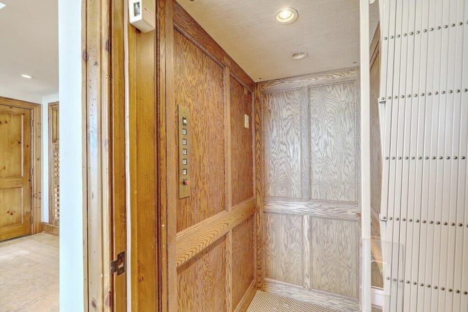 Private in-home elevator with wood paneling for added convenience and a touch of luxury.