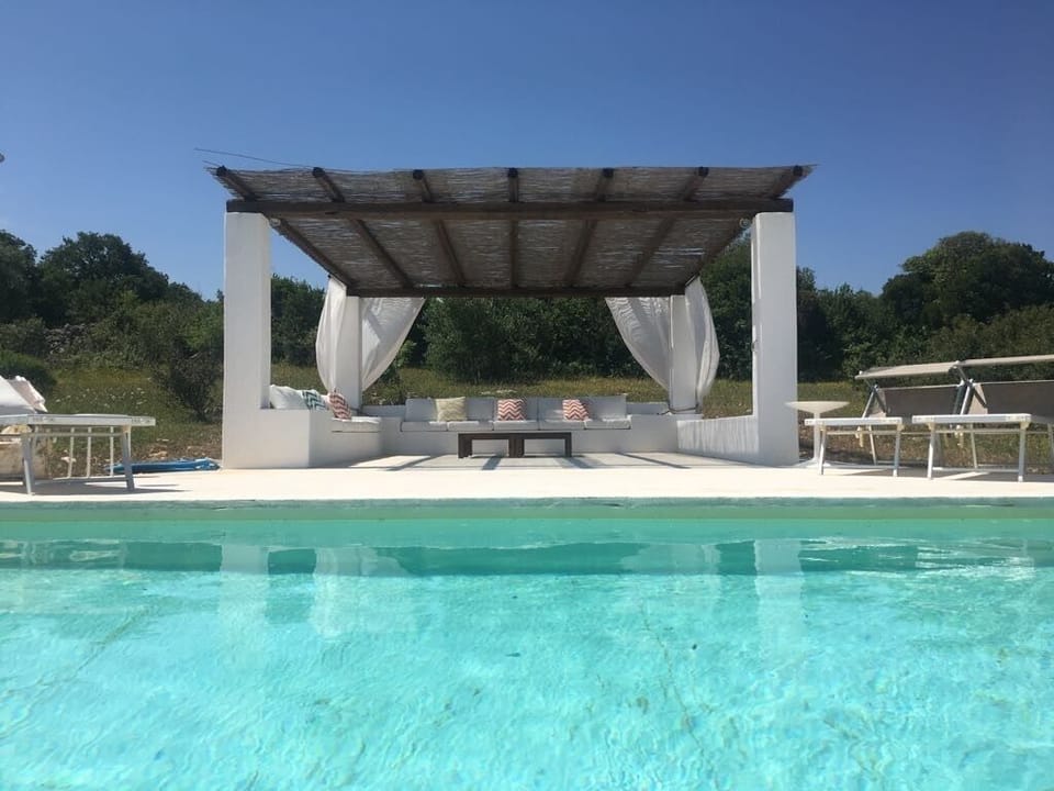 Pool area with sun-loungers and couches to enjoy lazy days by the pool
