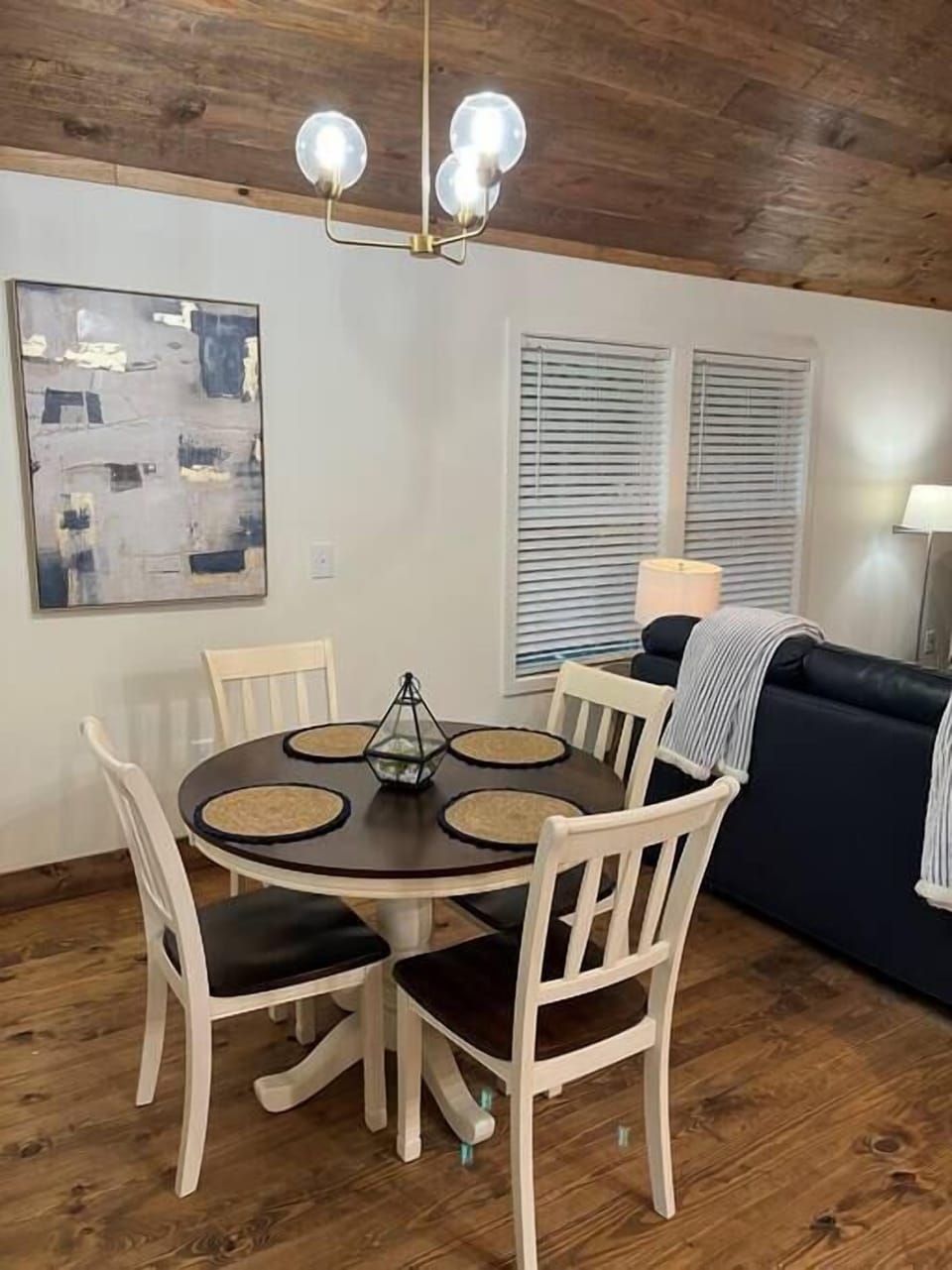 Dine in your open concept area. It features gold fixtures and modern art. 