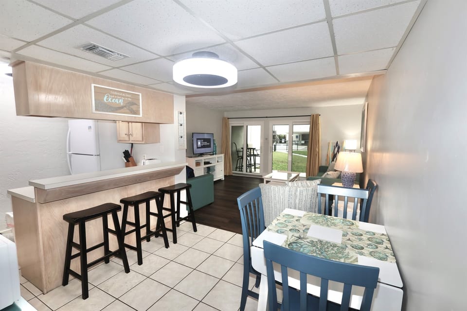 Fully equipped kitchen, dining area and bar seating — ideal for home-cooked meals after a day at the beach.