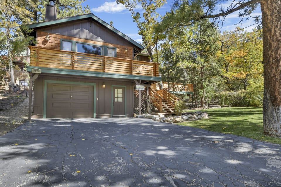 Welcoming cabin entry surrounded by towering pine trees, offering fresh mountain air and a peaceful forest setting—the perfect first impression for your Big Bear Lake getaway.
