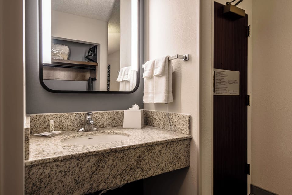 Refresh at the clean granite vanity with bright mirror lighting.