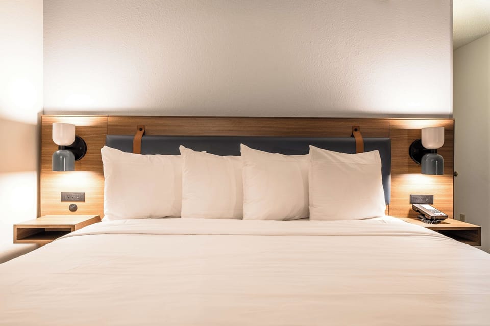 Recharge in hotel-fresh bedding with inviting bedside glow.