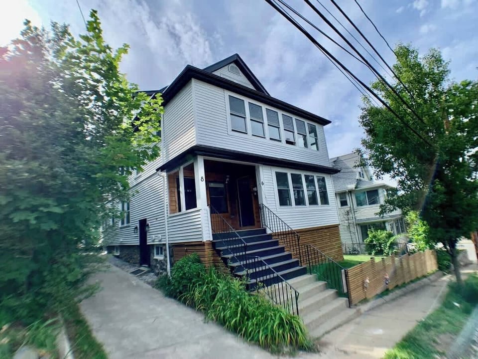 Corner view of the house. The apartment is located in the basement and you privately access it with the door on the left, via the driveway. 