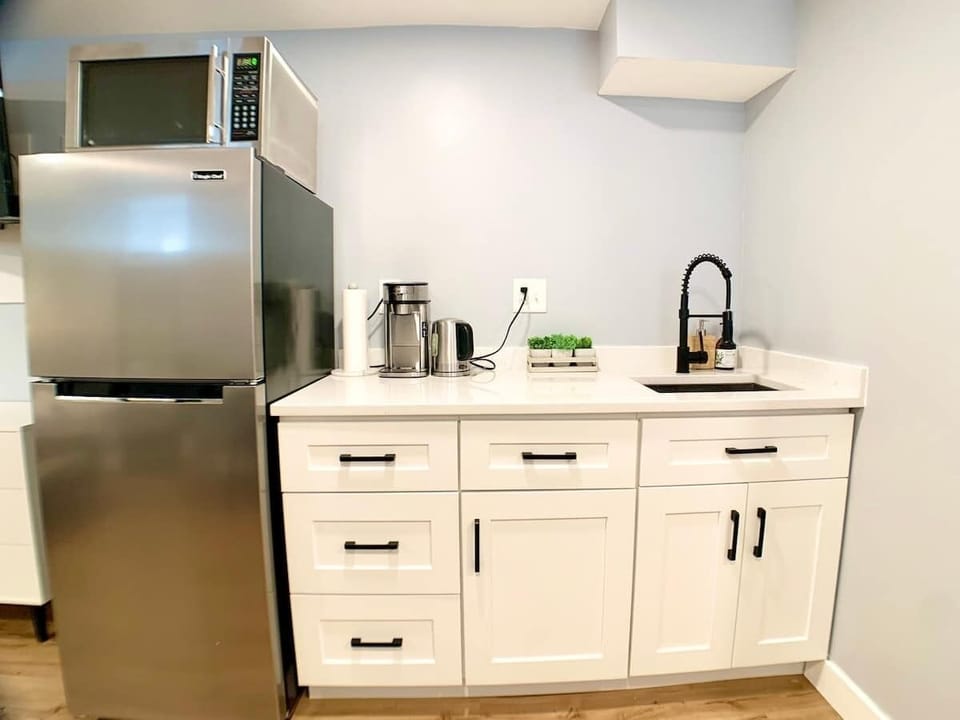 Front view of the kitchenette. 
We have a portable induction hotplate, stored inside the cabinets.
The coffee maker works with ground coffee. 
We provide utensils, silverware, dining ware, etc. 