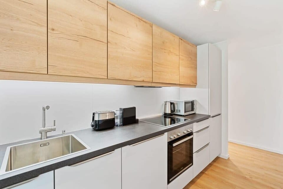 Fully equipped modern kitchen with sleek appliances and ample storage.