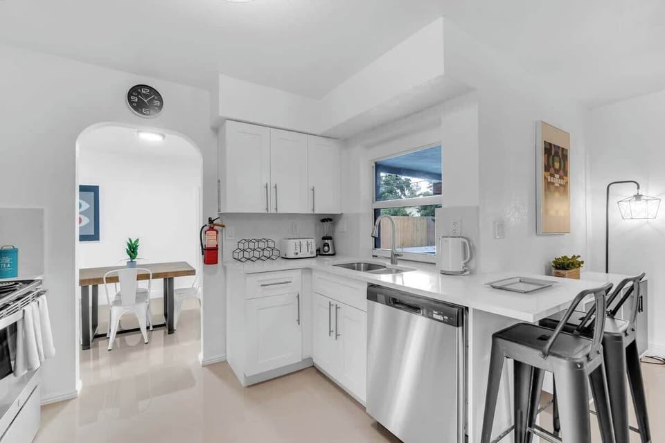 "Cook, dine, and unwind in this bright Airbnb kitchen—stainless steel appliances, cozy breakfast bar, and open layout perfect for family meals and relaxed vacation vibes."