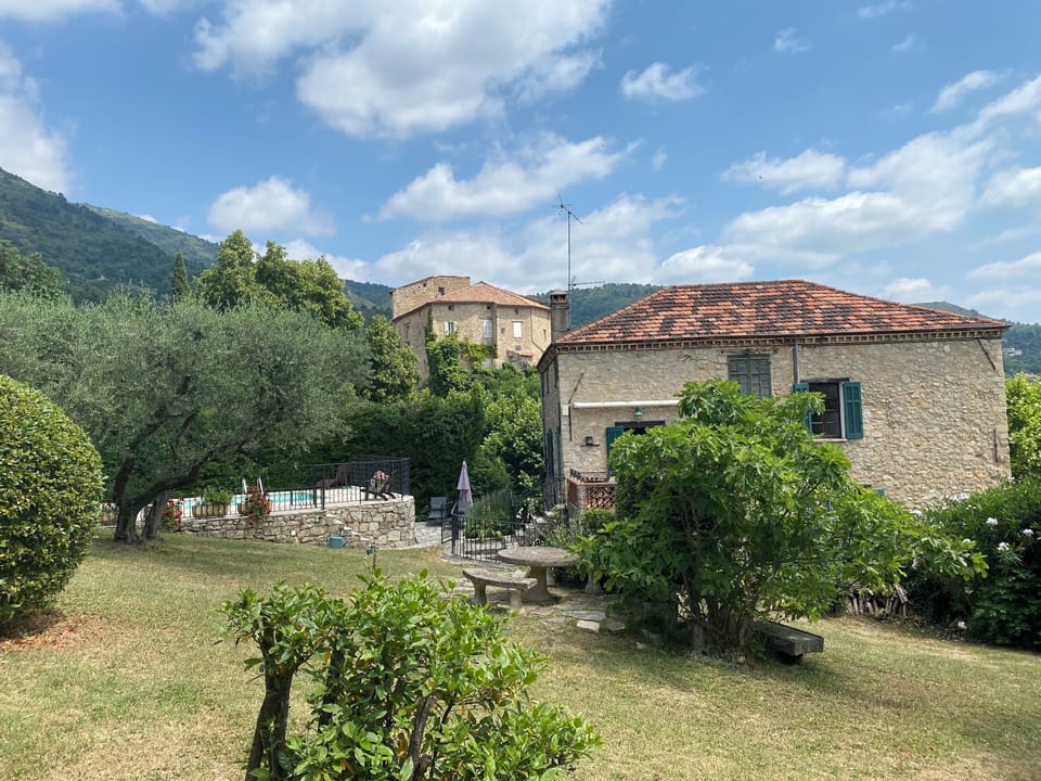 Garden view of house and pool terrace, with chateau in background.