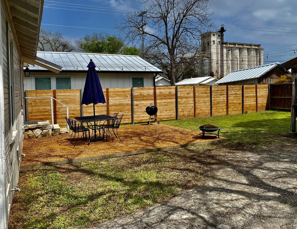 Outside dining area with charcoal grill and small fire pit for s’mores.