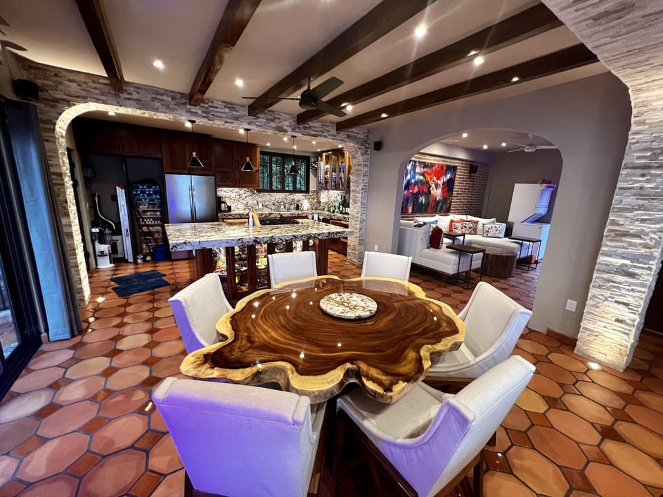 Inside dining with view of chef kitchen and home theater open to living area.