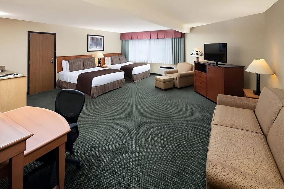 Unwind in a spacious double-queen room with cozy seating.