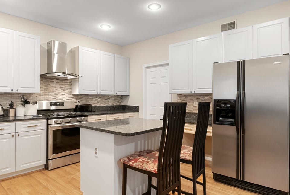 Beautiful kitchen having center slab with two dedicated chairs.