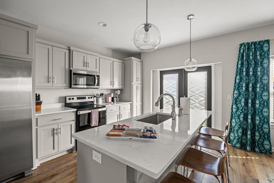 Fully stocked kitchen with quartz countertops and stainless steel appliances