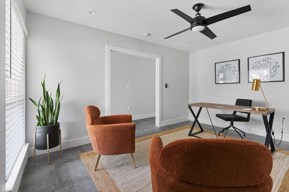 Dedicated home office with modern desk, chair, and cozy seating