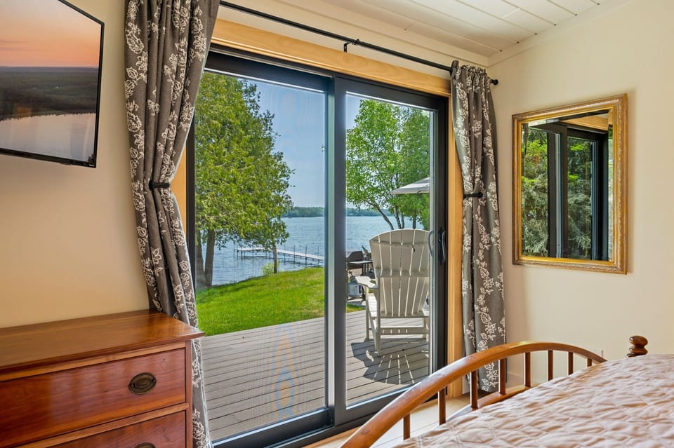 The primary bedroom has direct lake views and doors to our lakeside deck.