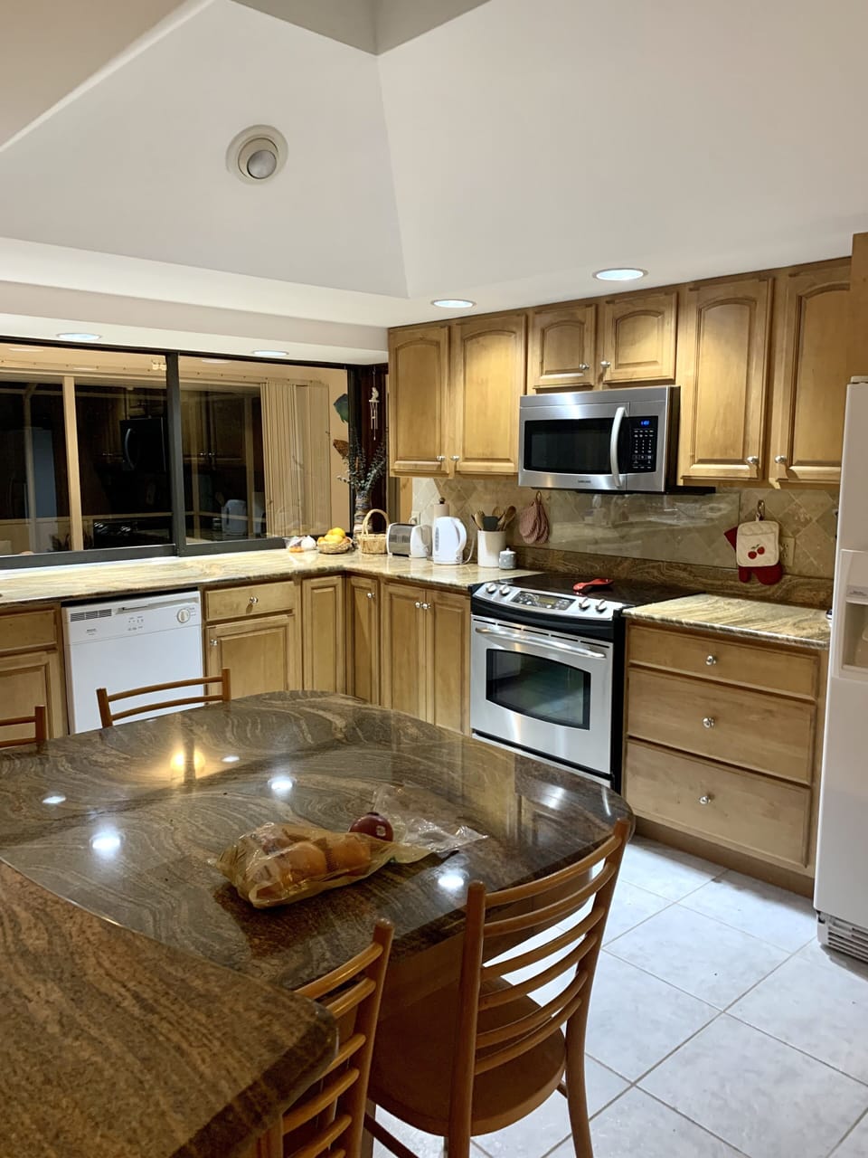A well-appointed eat in kitchen with a view of the pool.