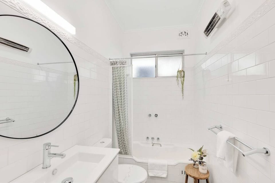 The light and modern bathroom includes a bathtub where guests can indulge in a relaxing soak after a day of sightseeing.
