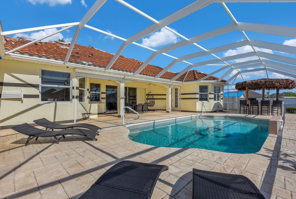 Private pool deck with loungers and tiki hut