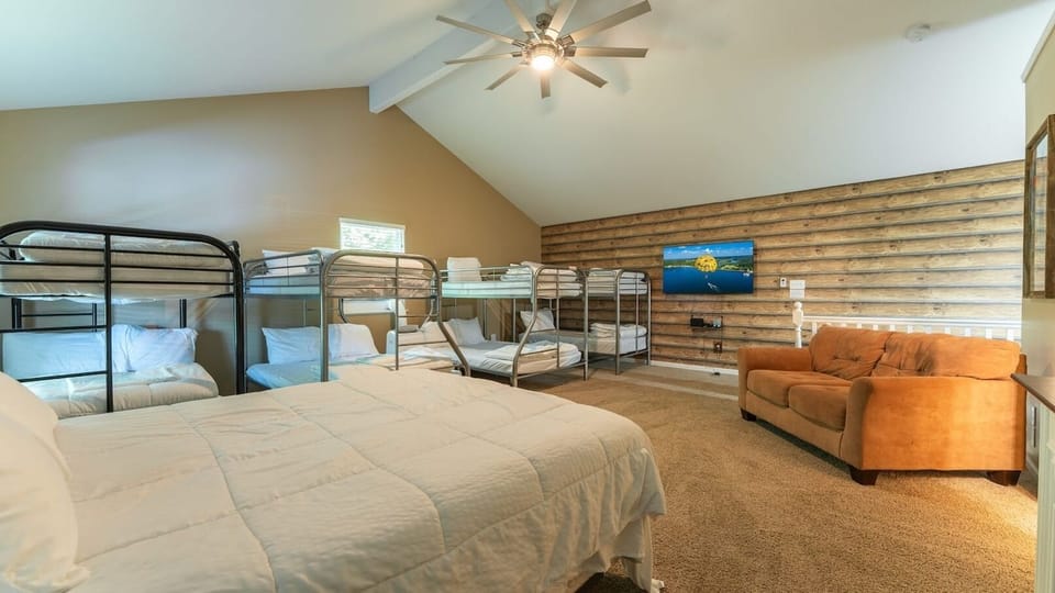 Bunkroom! This bunk room sleeps 12! One Queen Bed, 6 Twin Beds, and 2 Full Beds. This room includes a couch, large closet, AC, and a Full Bathroom.