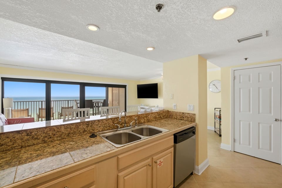 Ocean Breeze E601- Your kitchenette features granite counters and stainless steel appliances, with stunning ocean views through the sliding glass doors leading to your balcony.