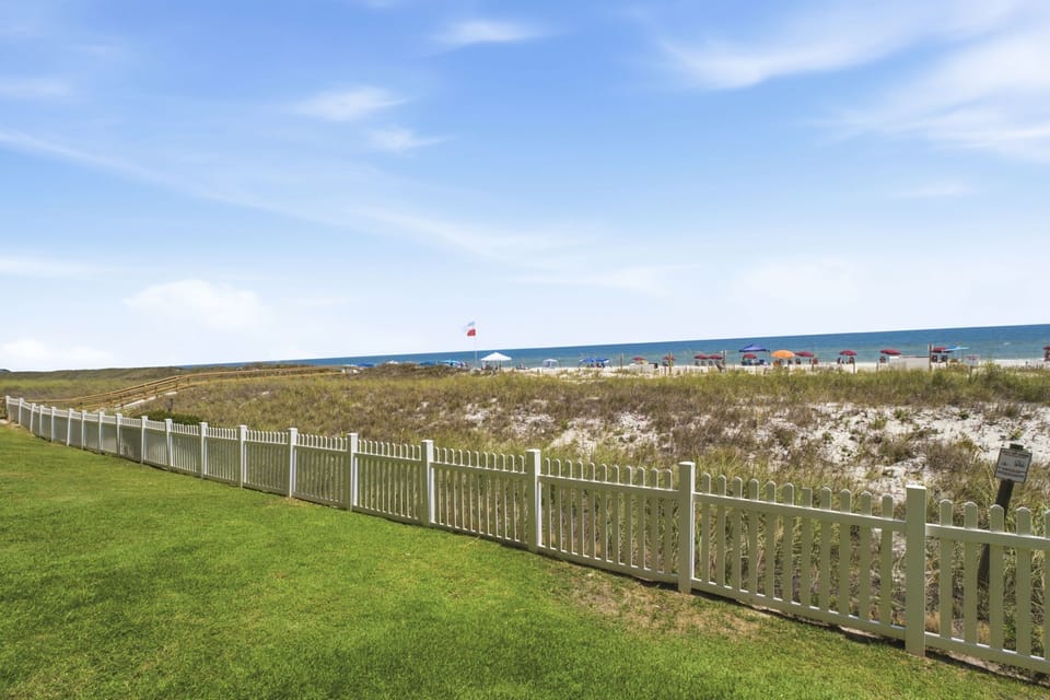 Ocean Breeze W 105- The property borders natural dunes and beach access, with the Gulf waters stretching toward the horizon. Beachfront location with direct access to sandy shores.