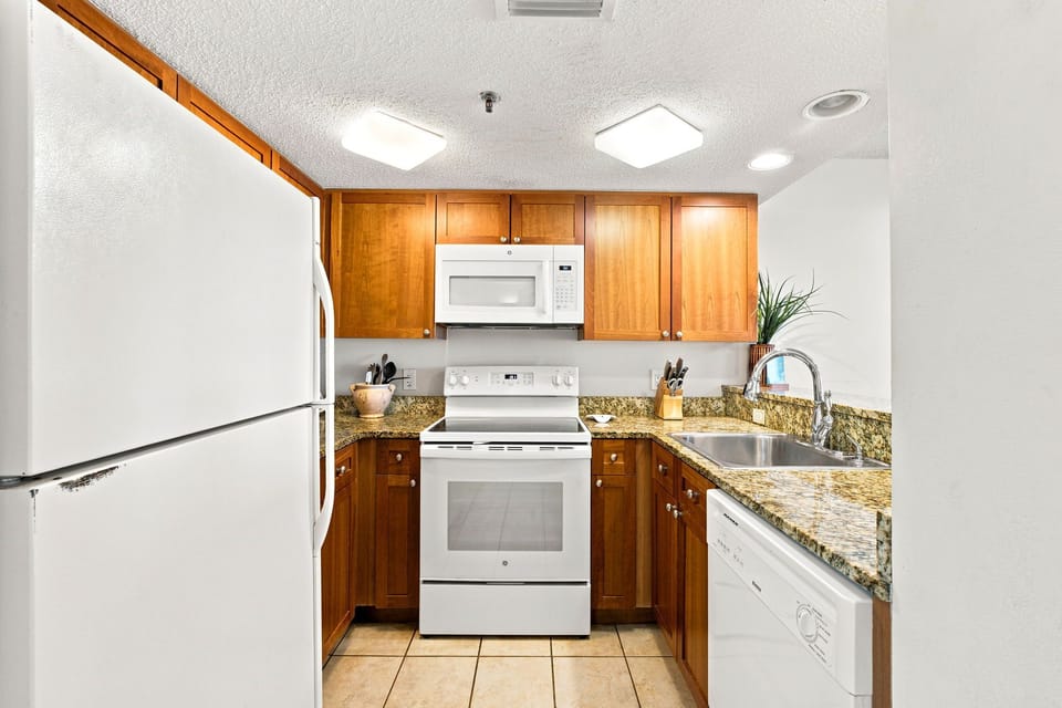 Ocean Breeze W 105- Your fully equipped kitchen makes meal prep a breeze with gleaming granite countertops, warm wood cabinetry, and modern appliances including a microwave and stove—everything you need to cook like you're at home.