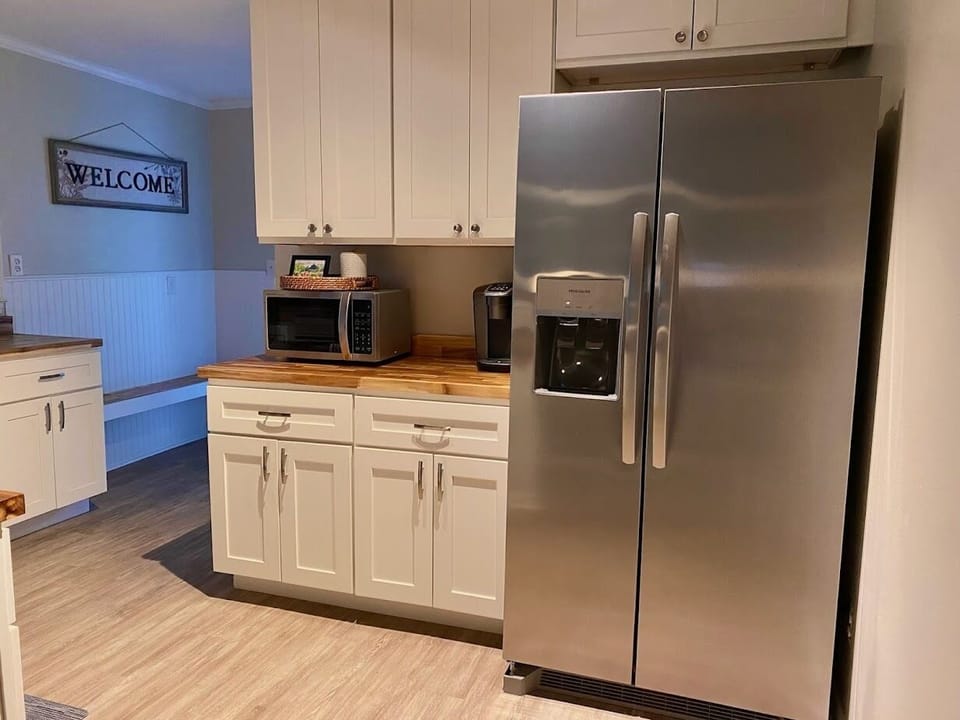 Large stainless steel refrigerator with water and ice on the door.
