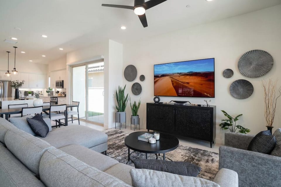 Bright, open living room w/ plush seating, modern fireplace & large TV for cozy nights in