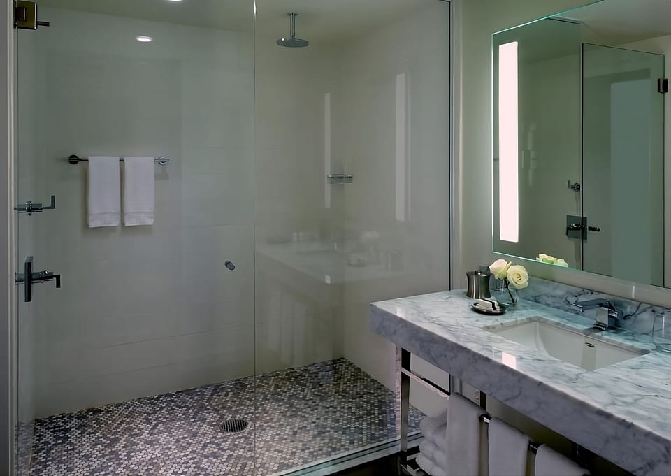 Start the day at a marble vanity with bright mirror lighting.