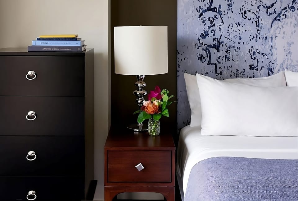 Enjoy thoughtful bedside details with warm lighting and fresh blooms.