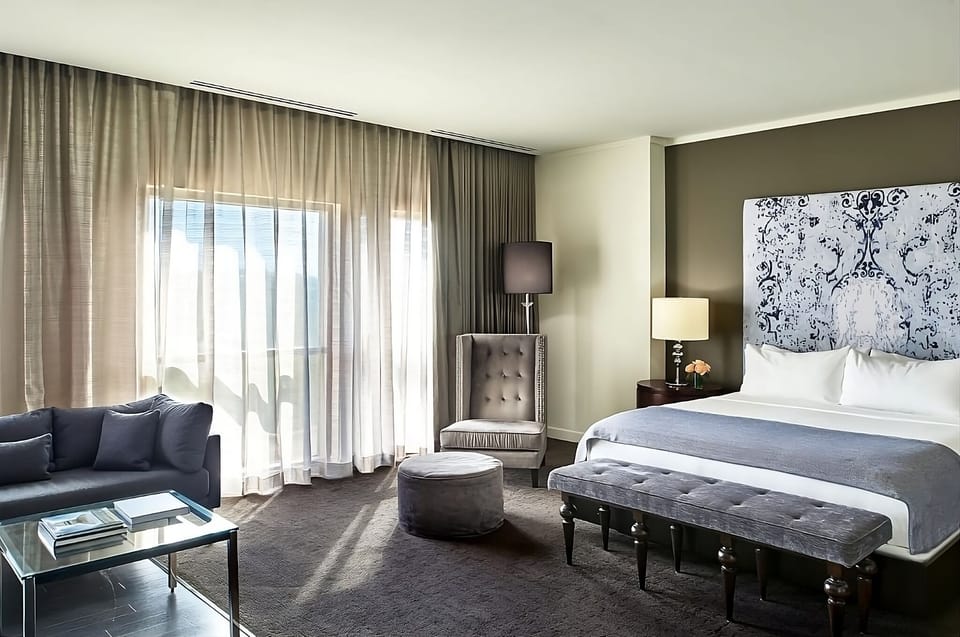 Lounge in a sunlit suite with plush seating and calm tones.