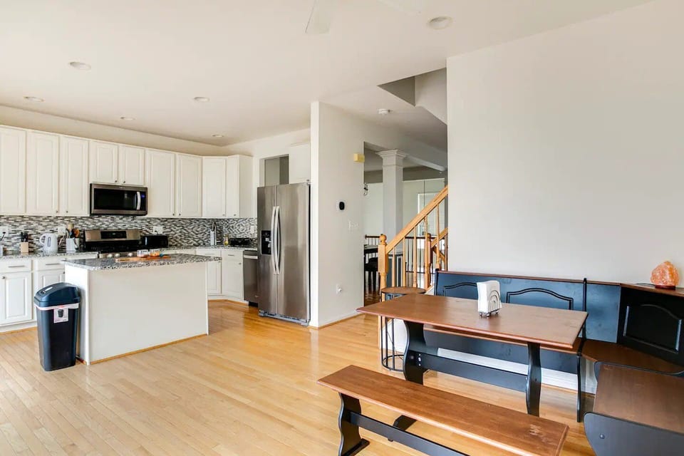 A zoomed-out view of the kitchen and the sitting area opposite each other.