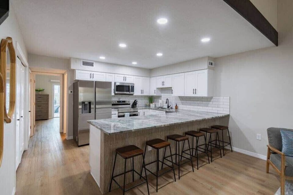 Modern kitchen with a large marble island and seating for six.