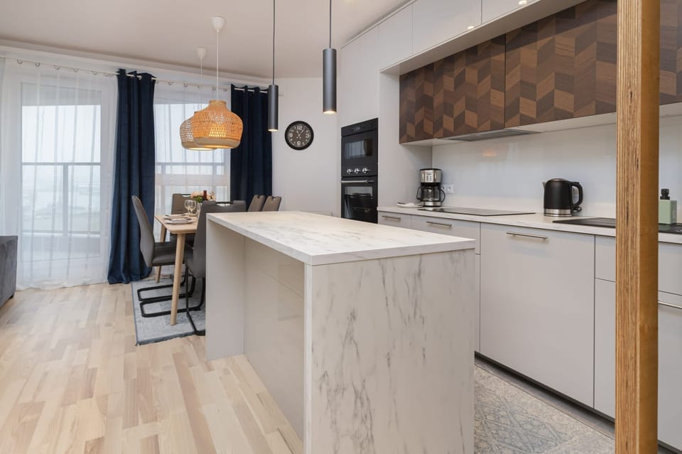 A modern kitchen with wooden cabinets, a sleek island, and all necessary appliances.