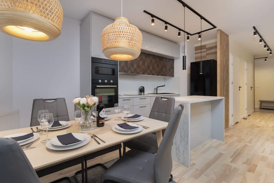 A dining table with modern chairs and elegant lighting, perfect for shared meals.