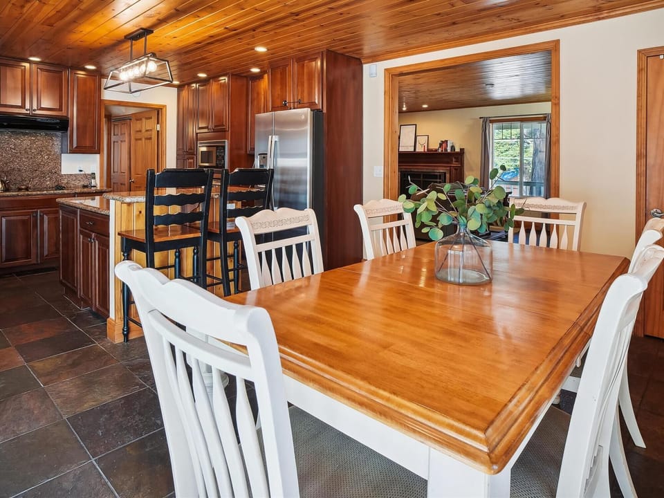 Spacious dining area with a rustic wooden table, ideal for family meals and gatherings.
