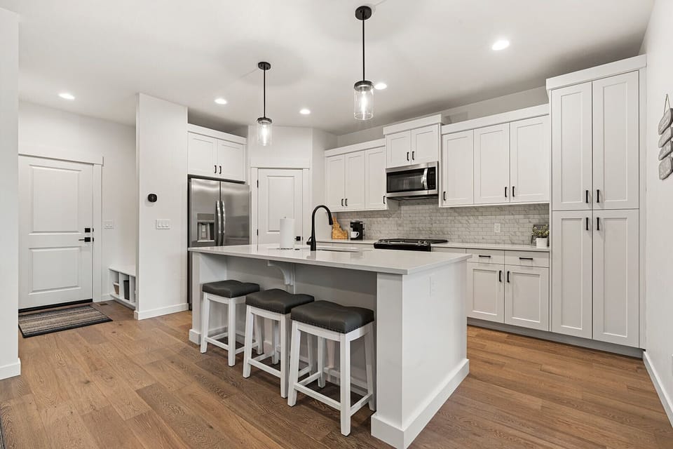 Plenty of space to cook, white quartz countertops and pendant lighting