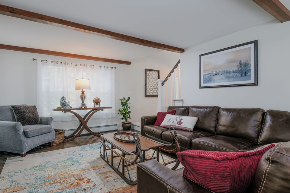 Bright, open-concept living area with comfy seating. Ideal for groups + families