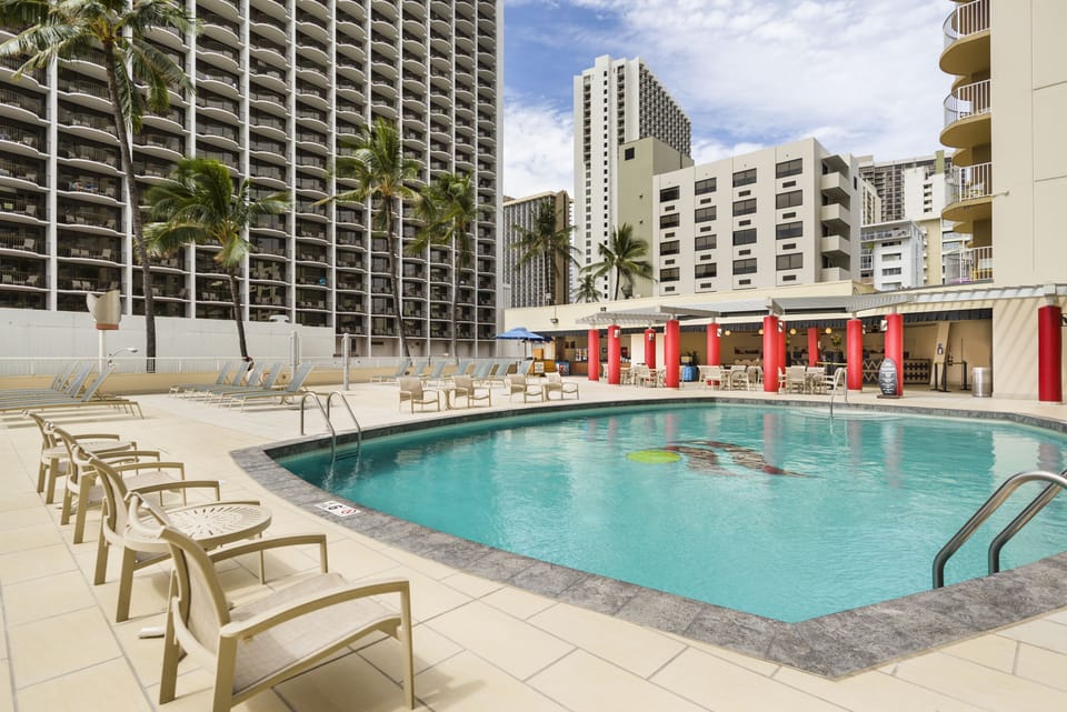 Dive into a sunlit pool oasis with plenty of loungers.