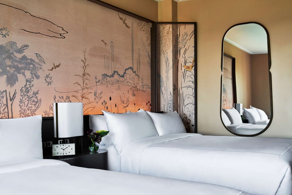 Unwind into crisp linens beneath striking, storybook wall art.