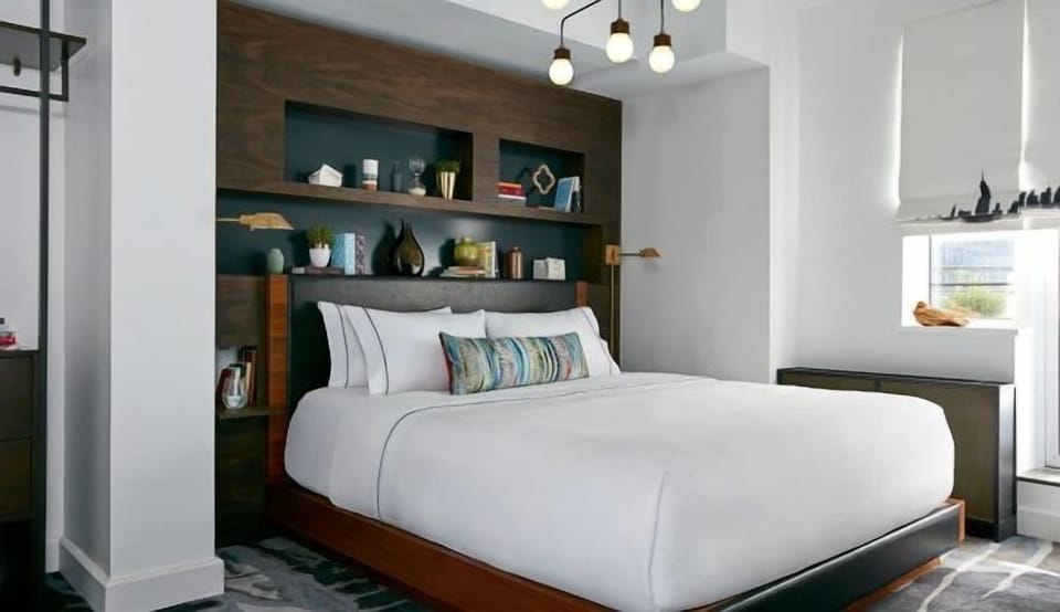 Drift off in crisp linens under soft, modern ambient lighting.
