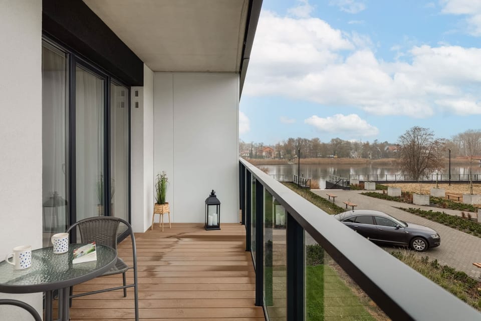 A balcony with outdoor chairs and a small table, offering a peaceful spot to enjoy the surrounding greenery.