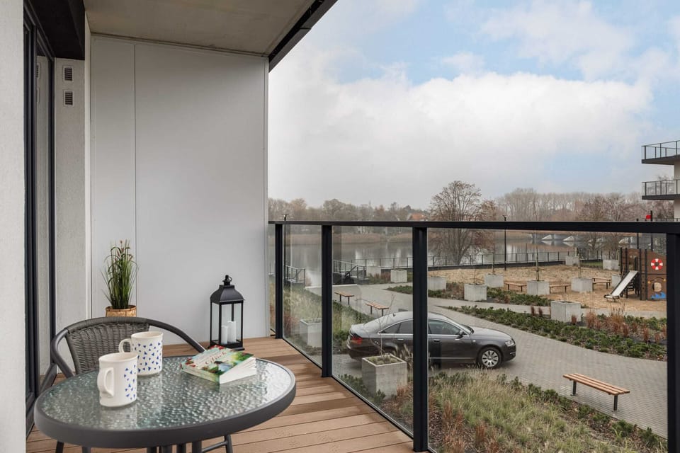 A balcony with outdoor chairs and a small table, offering a peaceful spot to enjoy the surrounding greenery.
