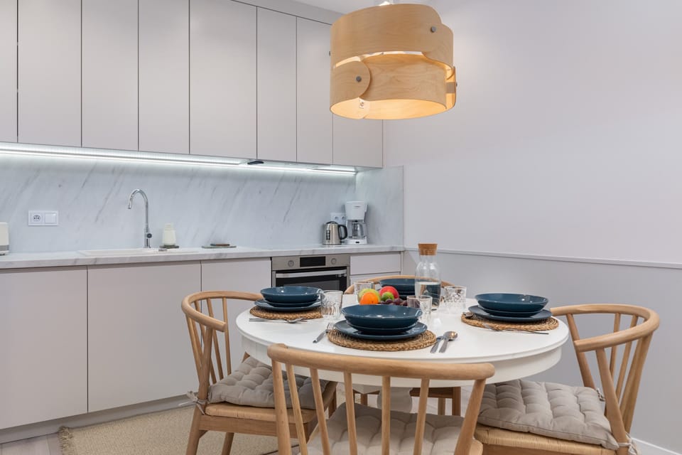 A modern kitchen with sleek white cabinetry, an induction cooktop, and all essential appliances.