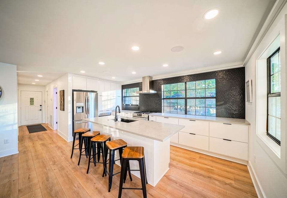Clean lines and wide-open flow make this kitchen and hallway the heart of the home — stylish, spacious, and ready for group stays.