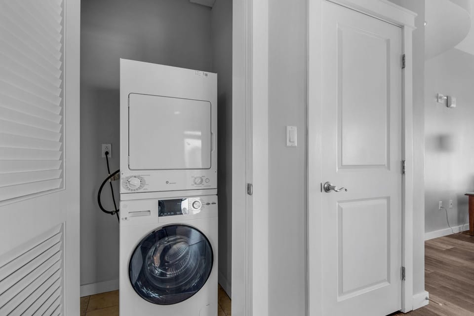 Laundry room includes large capacity washer and dryer.