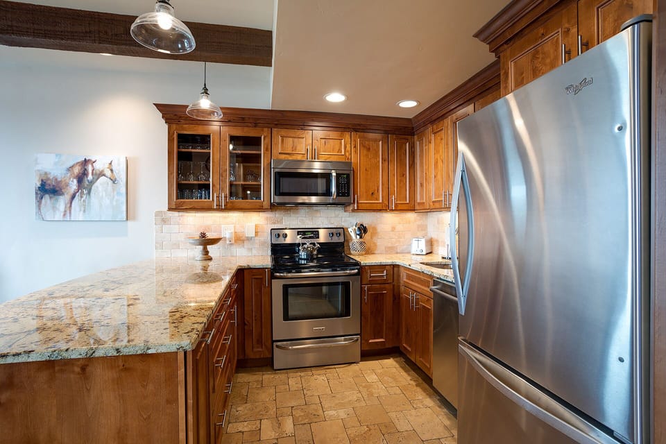 Your gourmet kitchen features warm wood cabinets, granite counters, and premium stainless appliances for memorable cooking experiences.