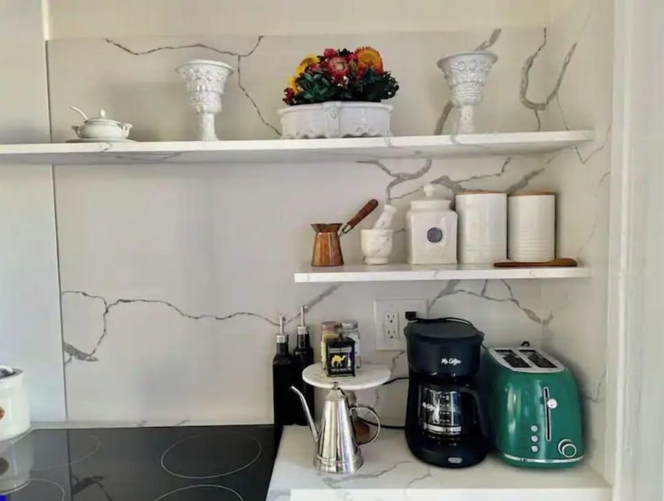 Marble shelving and cupboards with Victorian inspired kitchen utensils 