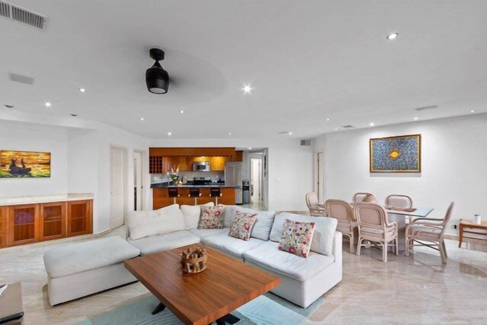 The living room has a comfortable l-shaped couch, ocean views, and a flat-screen TV